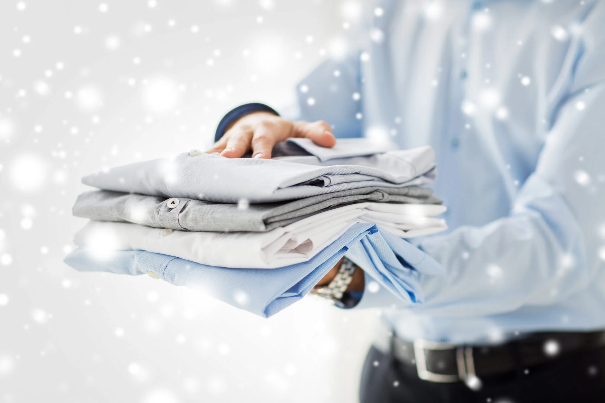 close up of businessman holding folded shirts